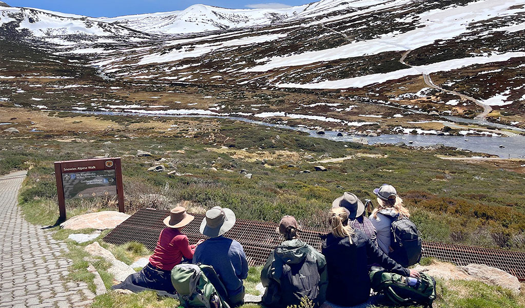 A tour group with She Wanders Escapes looking at snow-capped mountains in Kosciuszko National Park. Credit: Camilla Skye &copy; She Wanders Escapes