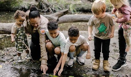 Children and an Aboriginal Discovery Ranger looking into a creek in Glenrock State Conservation Area. Credit and &copy; Zain Kruyer
