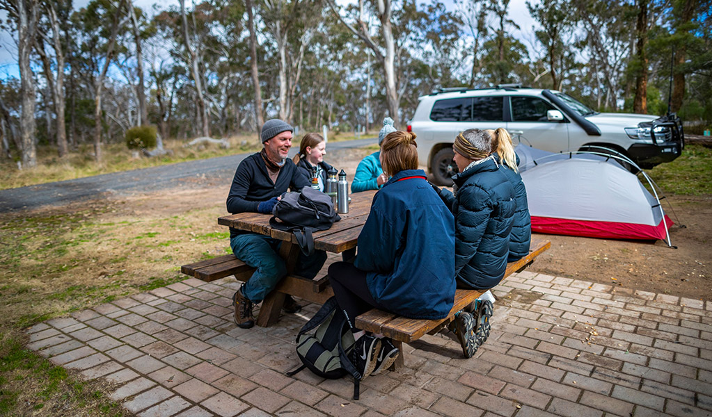 Four visitors enjoy a picnic lunch at Dangars Gorge campground, Oxley Wild Rivers National Park. Credit: Josh Smith/DCCEEW &copy; DCCEEW 