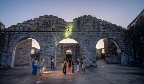 A group on a historical tour at sunset inside Trial Bay Gaol in Arakoon National Park. Credit: John Spencer &copy; DCCEEW