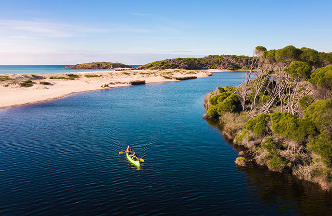 A person paddling down Bournda Lagoon in Bournda National Park. Photo: Daniel Tran/DPIE