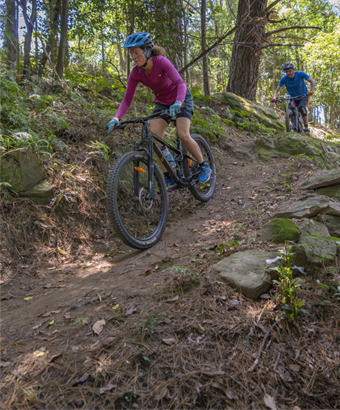 2 people riding mountain bike trails surrounded by forest in Illawarra Escarpment State Conservation Area. Credit: John Spencer &copy; DCCEEW 
