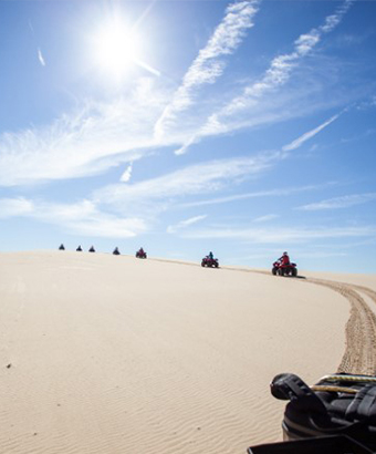 A tour group riding quad bikes on a tour of sand dunes with Sand Dune Adventures. &copy; Sand Dune Adventures. 