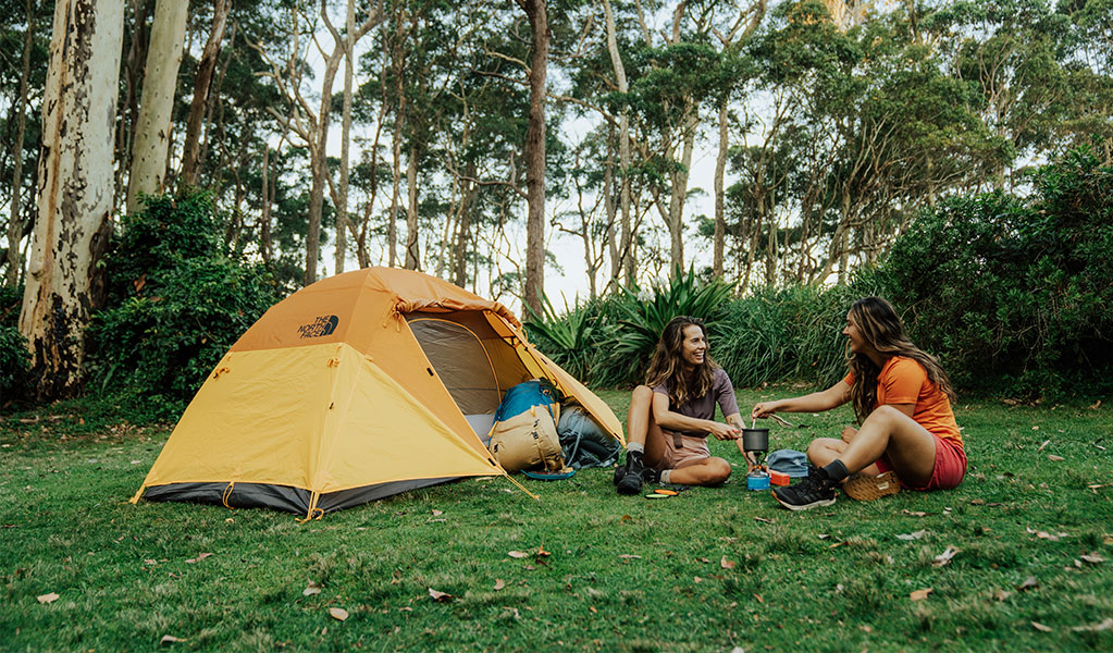 2 campers making coffee outside their tent at Depot Beach campground, Murramarang National Park. Photo: Remy Brand &copy; Remy Brand
