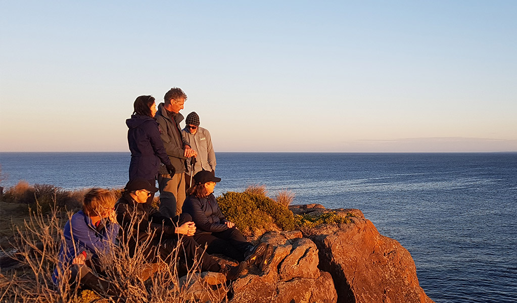 Group of people on cliff edge looking over the ocean in Beowa National Park. Photo: &copy; Park Trek Walking Holidays