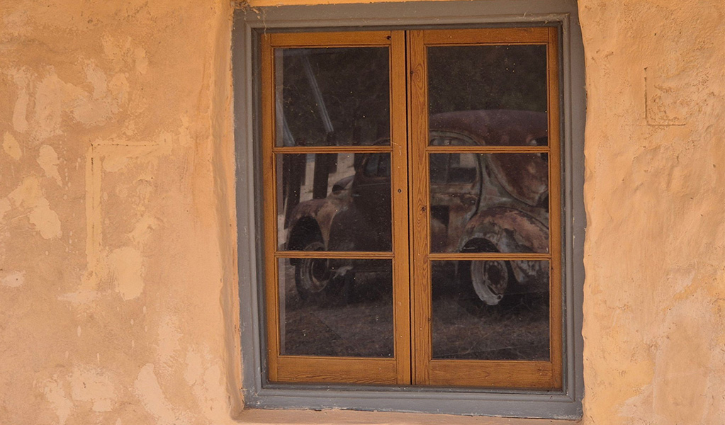Reflection of the old Renault car in a window at Teilta campground and picnic area. Credit: Gareth Telfer &copy; DCCEEW