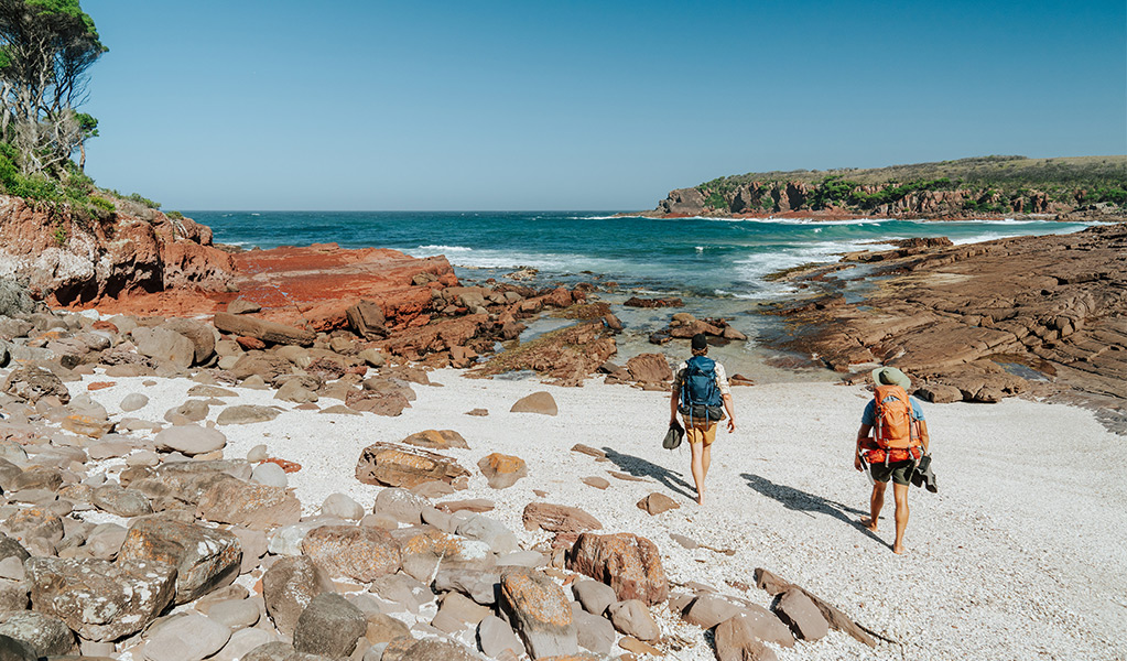 Hikers arriving at Hegartys Bay, a small rocky beach. Credit: Remy Brand/DCCEEW &copy; Remy Brand