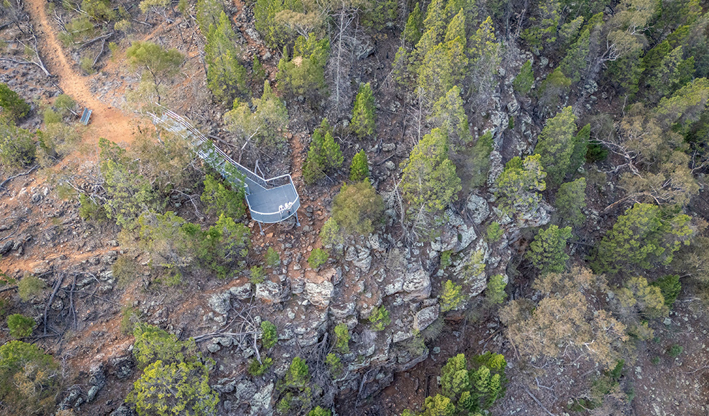 Two women stand at the steel railing of Jacks Creek lookout with views down into a gorge and expansive views out across country. Credit: John Spencer &copy; DCCEEW