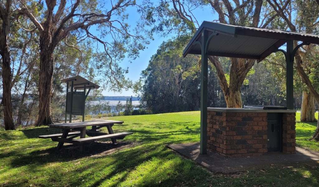 A display shelter, picnic table and barbecue shelter at Cudgen Lake picnic area in Cudgen Nature Reserve. Photo: Clare Manning &copy; DCCEEW