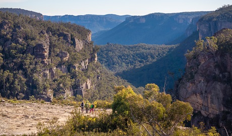 An aerial view of 3 hikers enjoying the view from Carne View lookout along Broad Swamp to Birds Rock walking track in Gardens of Stone State Conservation Area. Credit: John Spencer &copy; DCCEEW
