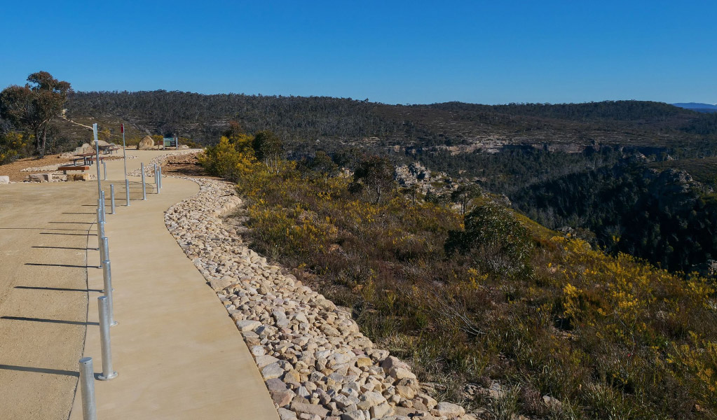 The concrete path from accessible parking spaces to the concreted viewing area with benches and picnic tables at Lost City North lookout. Credit: Claudia Abbott &copy; DCCEEW
