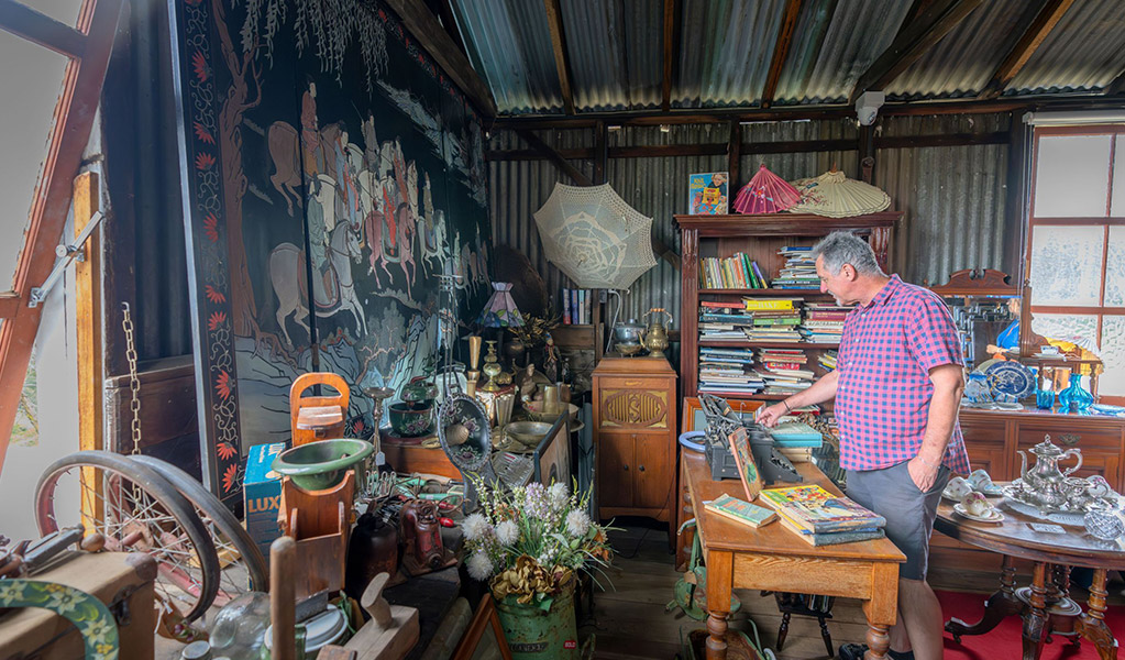 A visitor browsing antiques for sale at Gold Rush Antiques in Hartley Historic Site. Credit: John Spencer &copy; DCCEEW