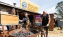 Workers hammering metal and stoking the coal fire out the front of the Talisman Gallery in Hartley Historic Site. Credit: Ben Pearse &copy; DCCEEW