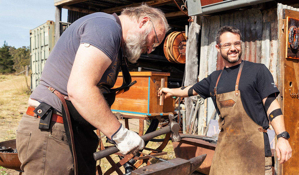 Two workers hammering metal out the front of the Talisman Gallery in Hartley Historic Site: Credit: Ben Pearse &copy; DCCEEW