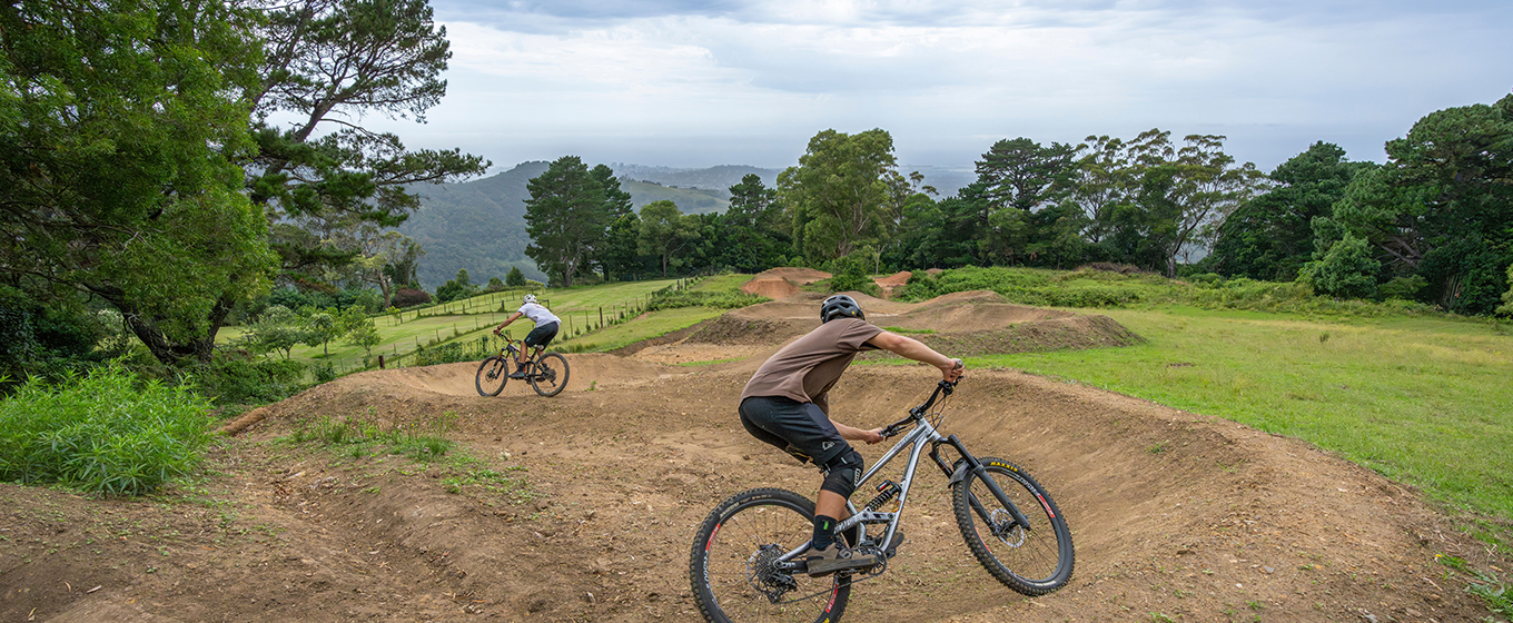 Mountain bike riders tackle the berms with views over the Illawarra to the ocean. Credit: John Spencer &copy; DCCEEW