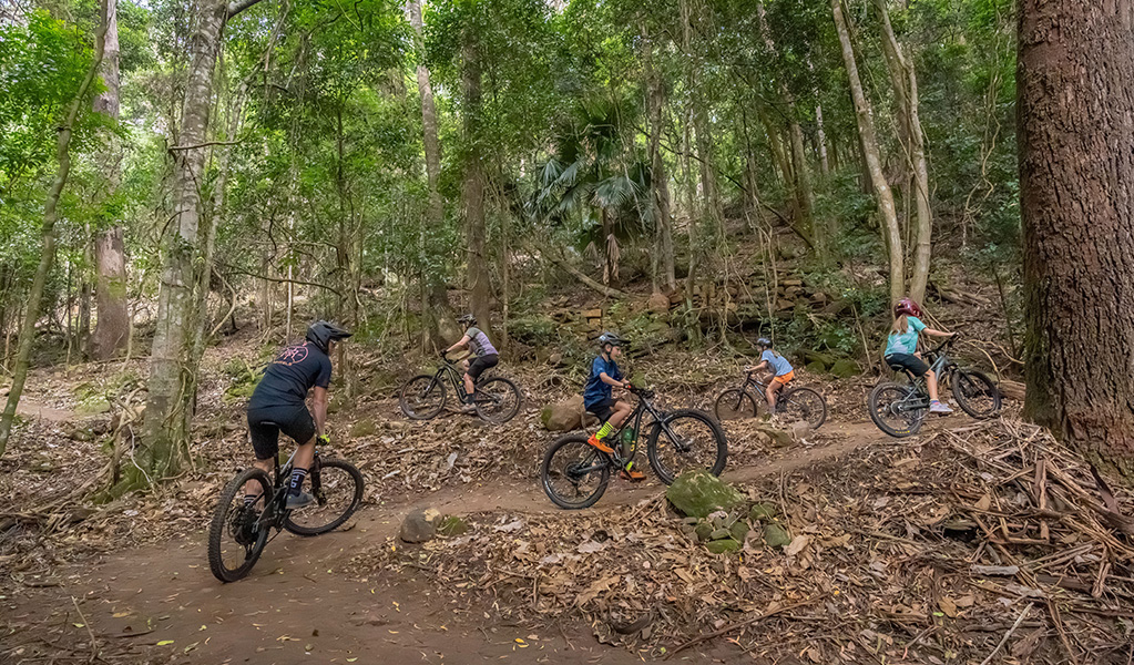 Riders of all ages and abilities ascend a one-way mountain bike trail. Credit: John Spencer &copy; DCCEEW
