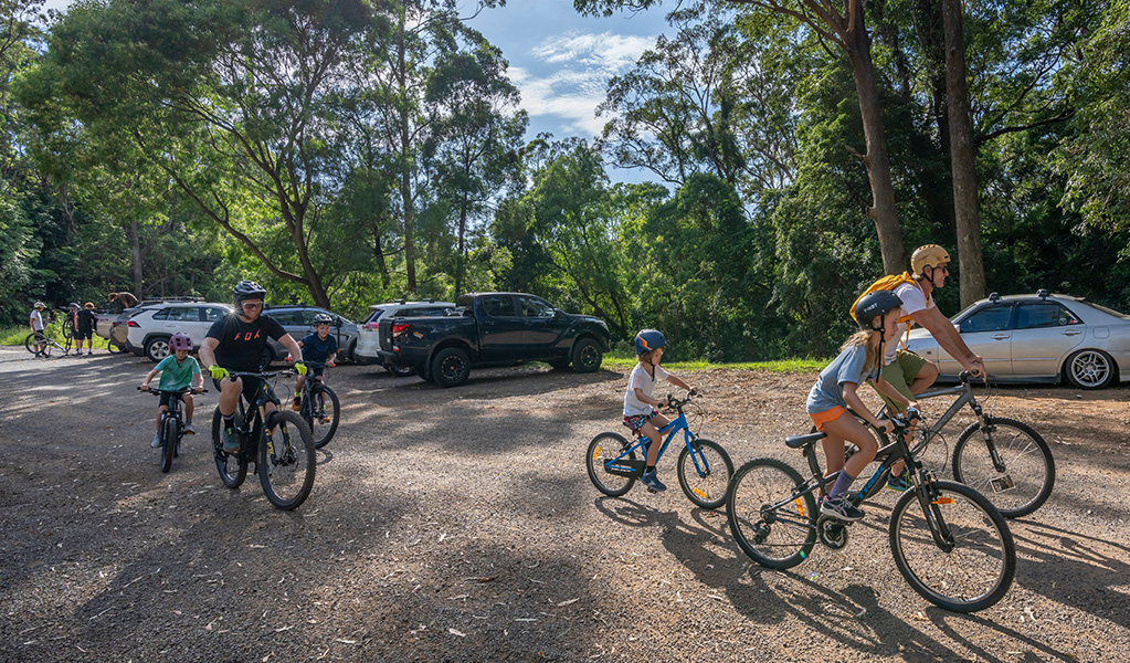 Two families with young kids on bikes set off from the carpark for a day of riding. Credit: John Spencer &copy; DCCEEW