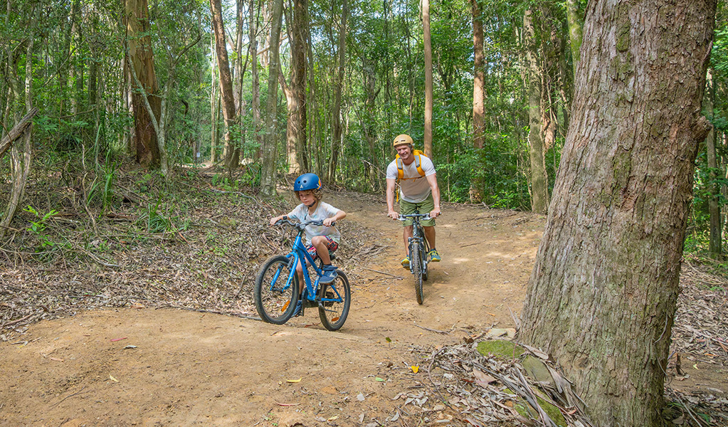 Dad and his 5 year old son wearing helmets and riding an easy green trail on Mount Kembla. Credit: John Spencer &copy; DCCEEW
