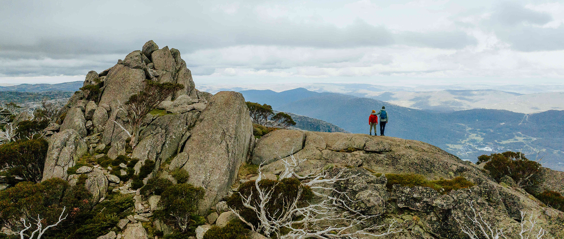 2 hikers on day 3 of Snowies Alpine Walk looking at valley views from Porcupine Rocks. Credit: Daniel Parsons / DCCEEW &copy; Caravel Content
