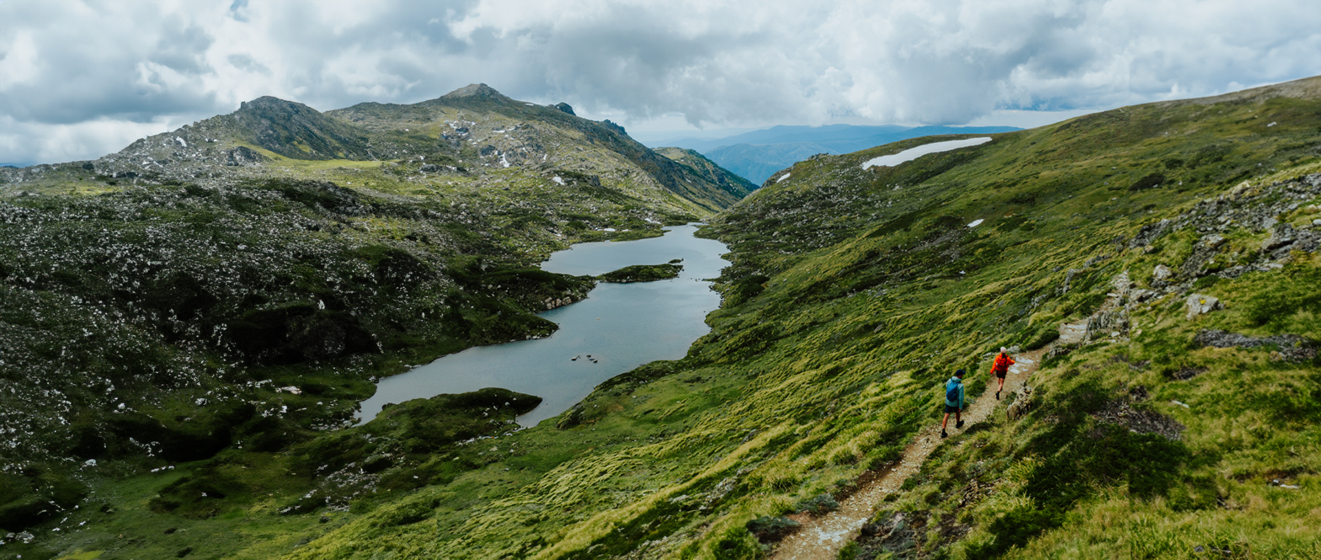 An aerial view of 2 hikers on Snowies Alpine Walk in the Thredbo-Perisher area with Blue Lake in the background. Credit: Daniel Parsons / DCCEEW &copy; Caravel Content