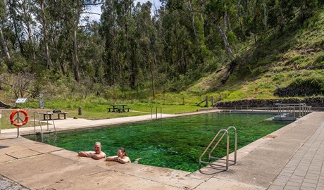 Two people relaxing in Yarrangobilly Caves thermal pool in the Yarrangobilly area of Kosciuszko National Park. Credit: John Spencer &copy; DCCEEW