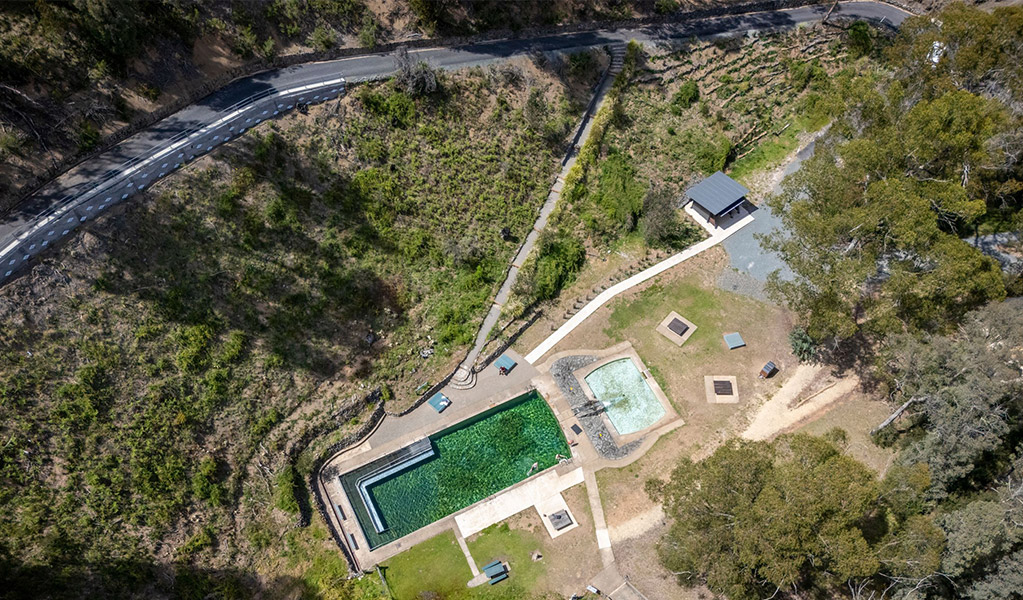 An aerial view on Yarrangobilly Caves thermal pool and picnic area including Yarrangobilly Caves thermal pool walk, the short but steep bitumen road down to the pool. Credit: John Spencer &copy; DCCEEW