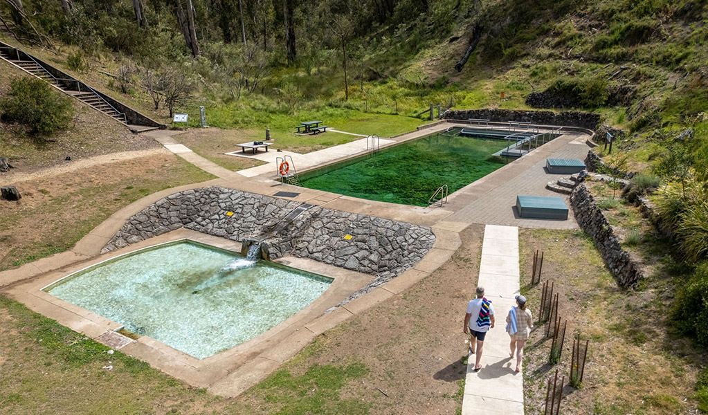Two people walking along the concrete path from the accessible change room and toilet towards the pool. Credit: John Spencer &copy; DCCEEW