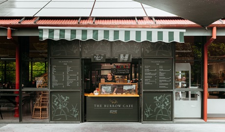 Exterior counter of The Burrow Cafe, with chalk menus and a staff member, Morton National Park. Credit and &copy;: Lily Crouch