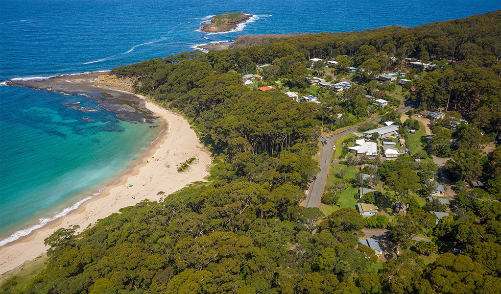 Aerial shot of Depot Beach cabins and campground, showing proximity to the beach in Murramarang National Park. Photo: John Spencer &copy; DPIE