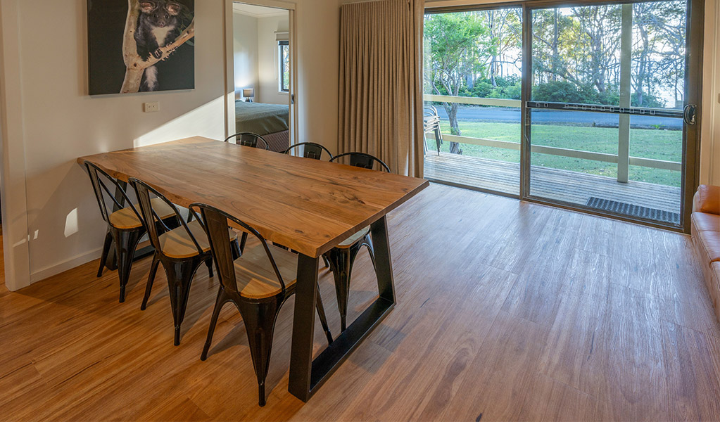 Dining table and verandah view at Depot Beach cabins. Photo: John Spencer &copy; DPIE