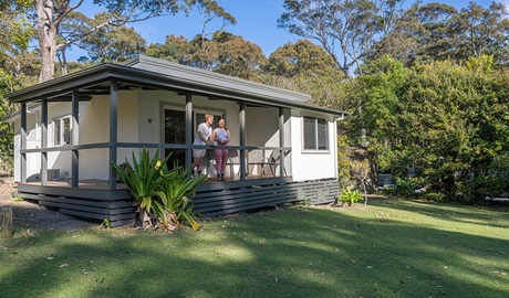 Guest on the verandah, Depot Beach cabins. Photo: John Spencer &copy; DCCEEW