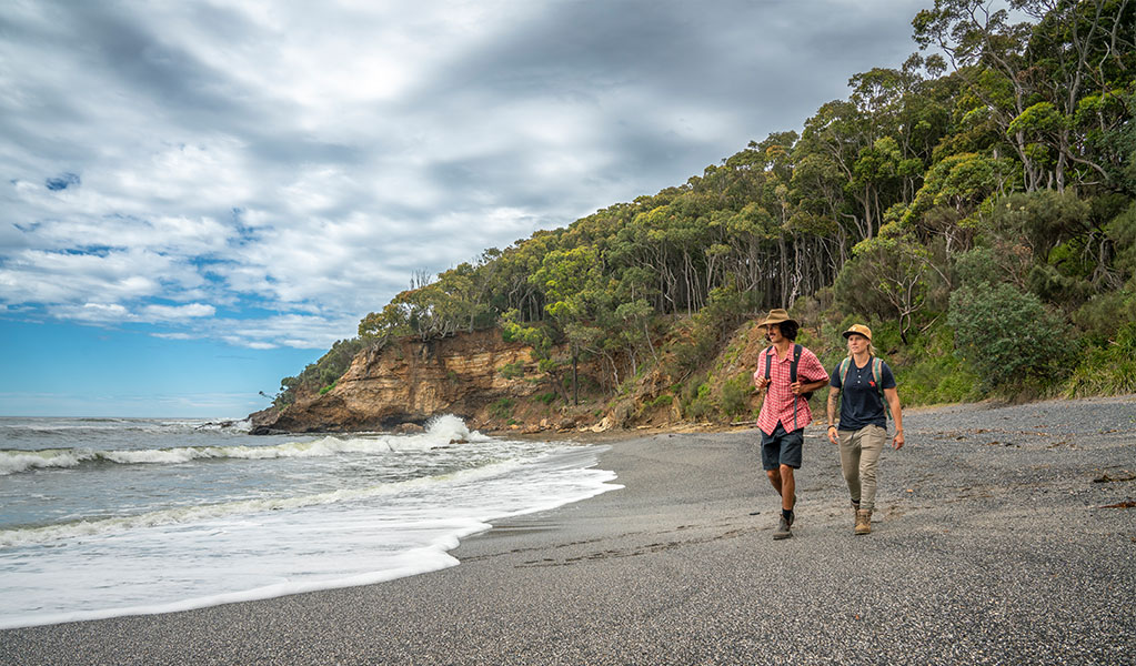 2 people walking on Dark Beach in Murramarang National Park. Credit: John Spencer &copy; DPE