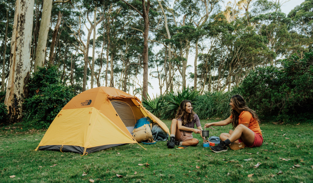 2 campers sitting outside their tent at Depot Beach campground, making coffee. Credit: Remy Brand &copy; Remy Brand