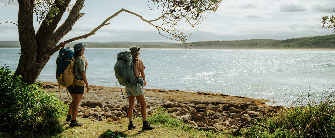 2 walkers admiring the coastal view from Calm Corner, North Durras Beach on the Murramarang South Coast Walk. Credit: Remy Brand &copy; Remy Brand