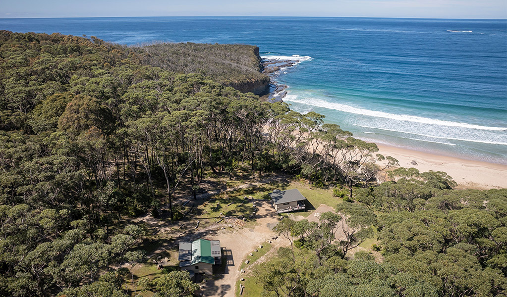 Aerial view of Pebbly Beach shacks, situated behind the beach. Photo: John Spencer &copy; DPIE