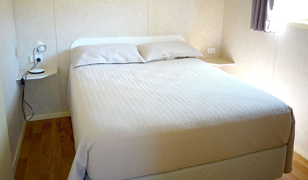 Room with double bed, Pretty Beach cabins. Credit: Billy Clare Reitzenstein &copy; DCCEEW