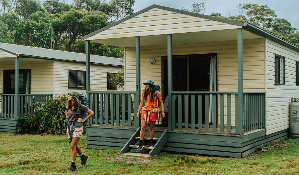 Guests in front of their Pretty Beach cabin. Credit: Remy Brand &copy; Remy Brand