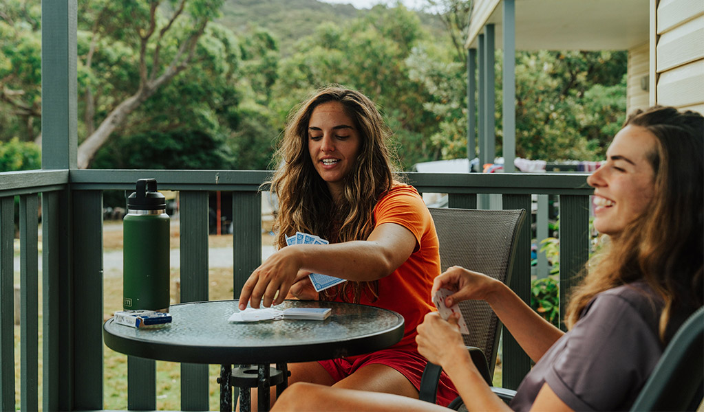 Guests on the verandah of their Pretty Beach cabin, Murramarang National Park. Credit: Remy Brand &copy; Remy Brand