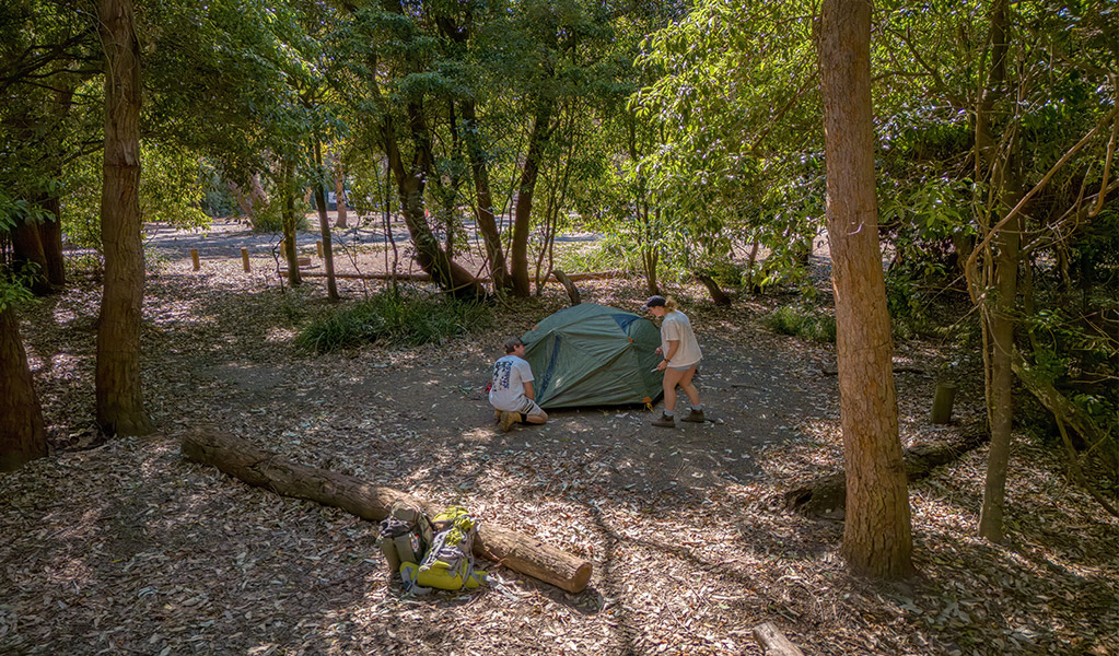 Campers setting up their tent at Pretty Beach campground. Credit: John Spencer &copy; DCCEEW