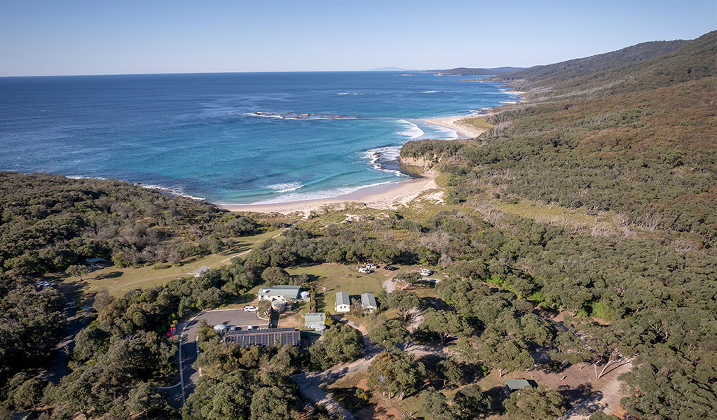 Aerial view of Pretty Beach campground and cabins, the ocean in the distance. Credit: John Spencer &copy; DCCEEW