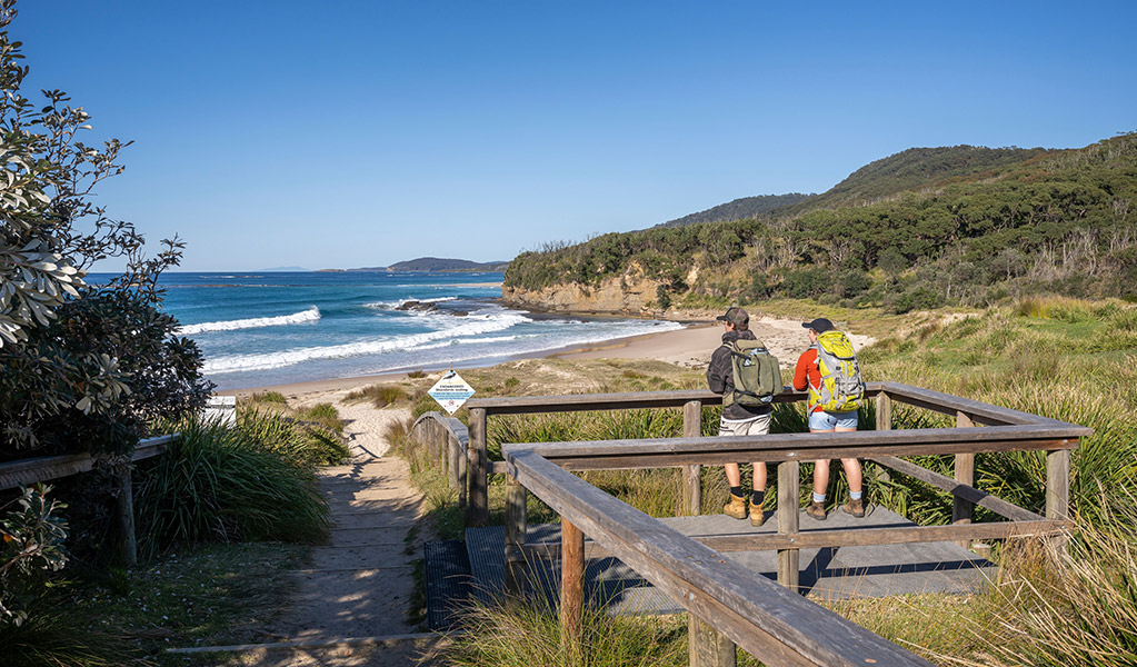 Visitors looking at the ocean views from a wooden platform, Pretty Beach picnic area. Credit: John Spencer &copy; DCCEEW