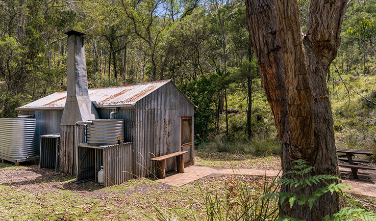 Birds Nest Hut is a small, restored stockmans hut with a fire and outdoor picnic table. Credit: David Waugh &copy; DCCEEW