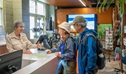An NPWS staff member assisting 2 visitors inside the Royal National Park visitor centre at The Royal National Park. Credit: John Spencer &copy; DCCEEW