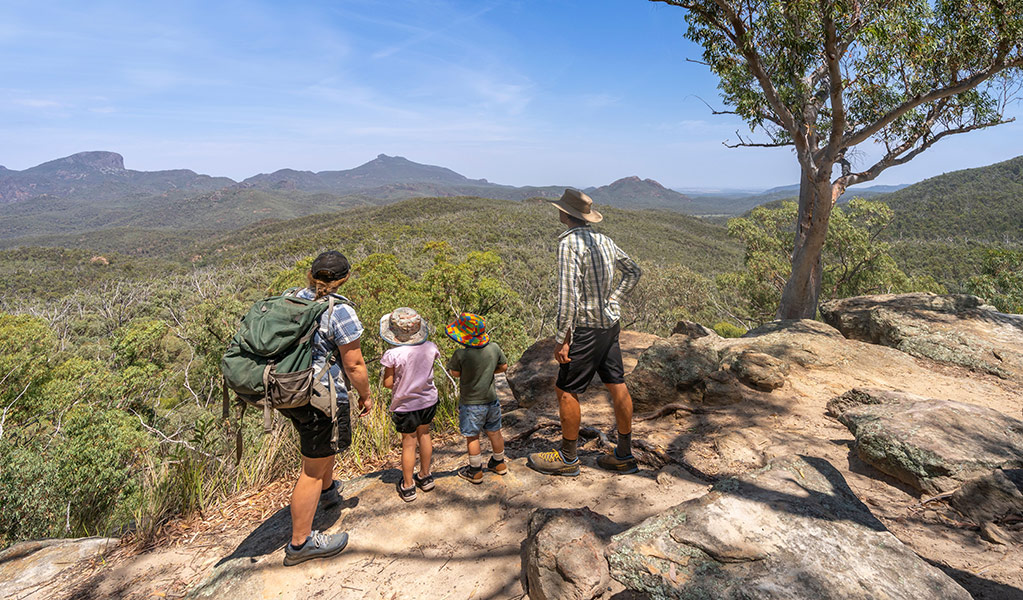 A family with young kids enjoying views of the volcanic landscape at Whitegum lookout. Credit: John Spencer &copy; DCCEEW