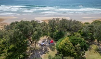 Aerial view of a tent campsite set back from the ocean at Illaroo campground. Credit: John Spencer &copy; DCCEEW
