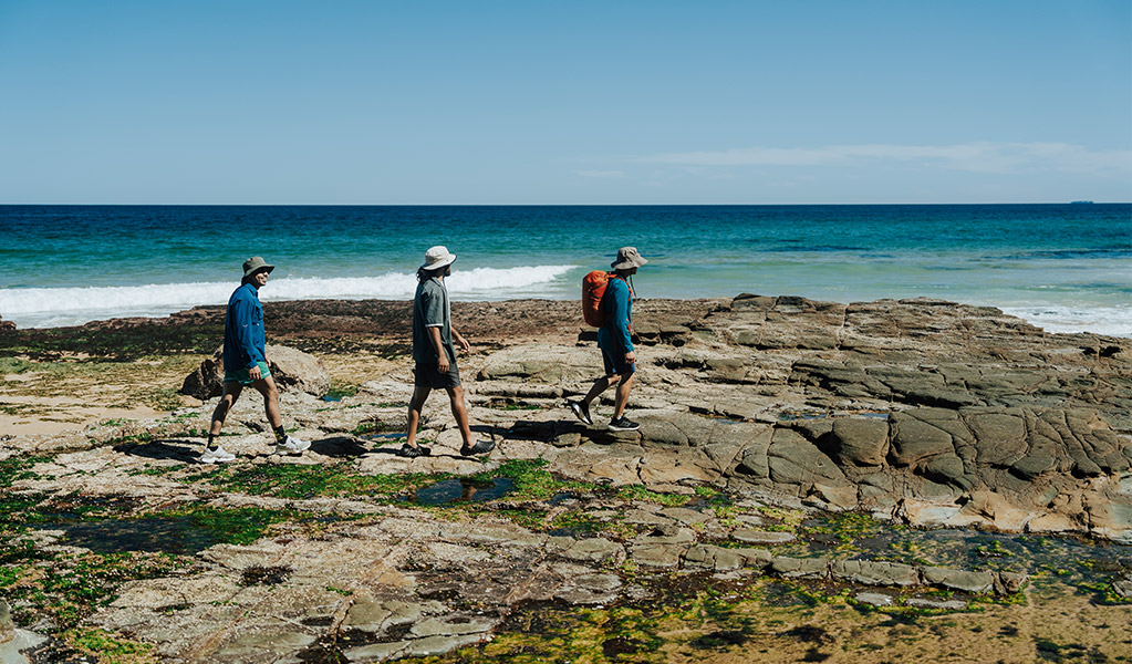 People walking safely across rock platform in a national park. Credit: Remy Brand/DCCEEW