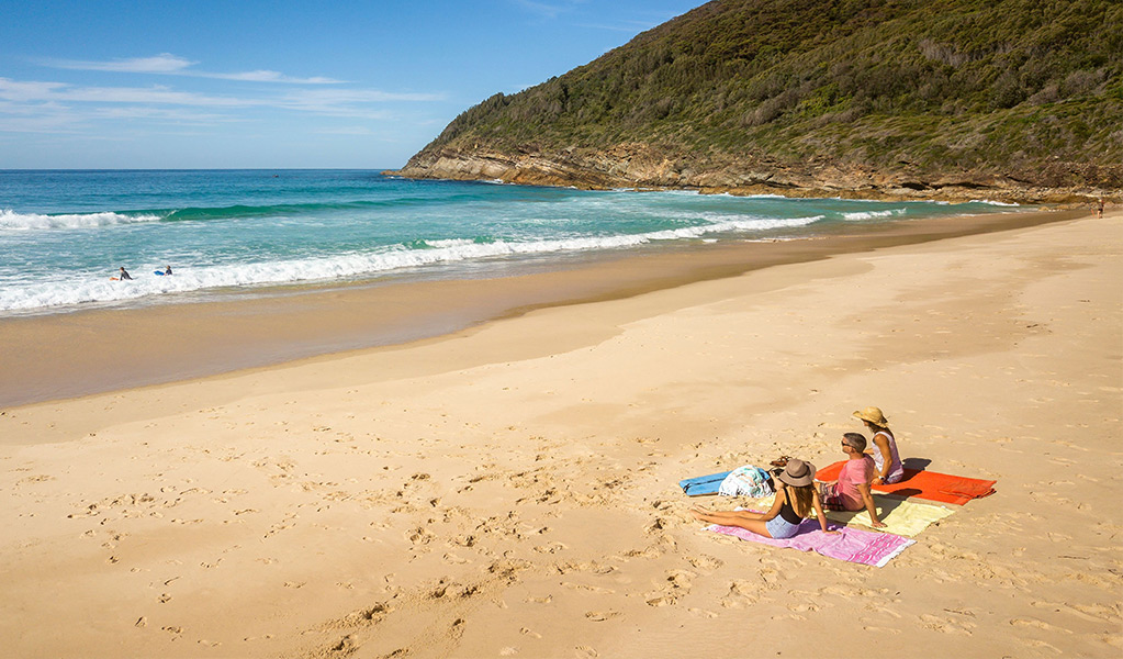 People relaxing on the sand at Seven Mile Beach. Photo: John Spencer &copy; DCCEEW