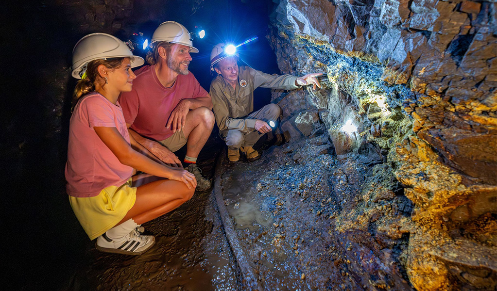 A volunteer tour guide showing visitors the rock structures at Mountain Maid gold mine in Copeland Tops State Conservation Area. Credit: John Spencer &copy; DCCEEW