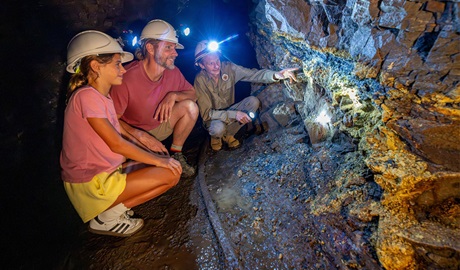 A volunteer tour guide showing visitors the rock structures at Mountain Maid gold mine in Copeland Tops State Conservation Area. Credit: John Spencer &copy; DCCEEW
